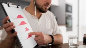 homem analisando dados em graficos de histograma em prancheta