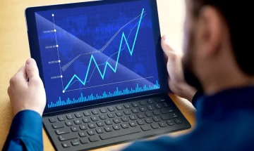 Pessoa analisando gráficos de crescimento financeiro em um tablet, indicando sucesso nos investimentos e aumento de lucros.