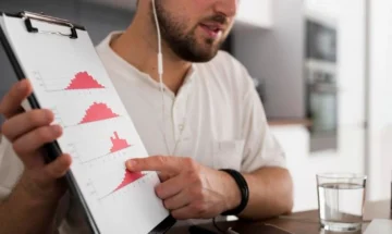 homem analisando dados em graficos de histograma em prancheta